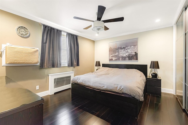 bedroom with ornamental molding, dark hardwood / wood-style floors, and ceiling fan