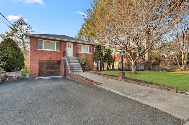 ranch-style home with a front lawn, aphalt driveway, fence, an attached garage, and brick siding