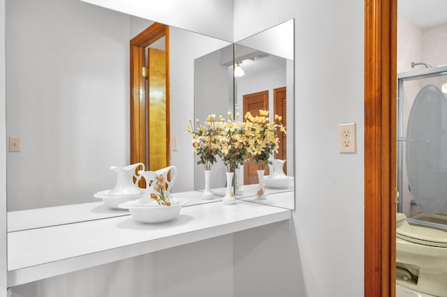 bathroom featuring a shower, toilet, and vanity