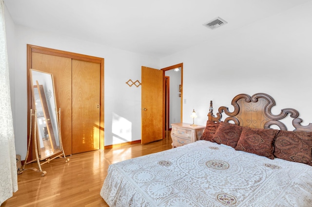 bedroom with visible vents, baseboards, and wood finished floors