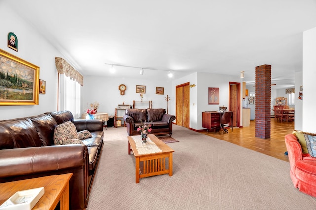 living room featuring light carpet, light tile patterned flooring, track lighting, and ornate columns