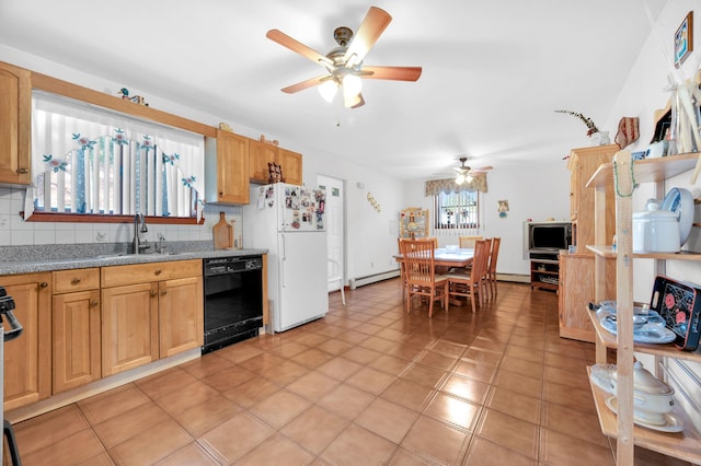 kitchen with a sink, backsplash, black dishwasher, freestanding refrigerator, and baseboard heating