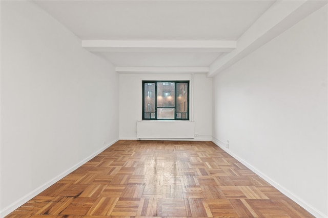 spare room with light parquet floors and beamed ceiling