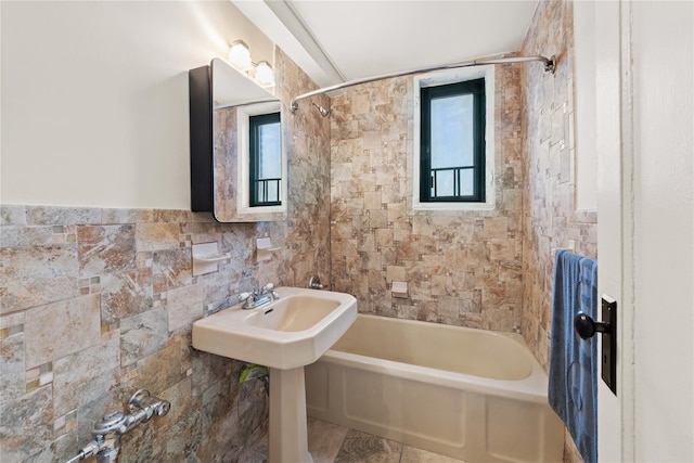 bathroom with tile walls and tiled shower / bath