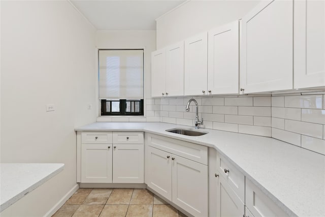 kitchen featuring light tile patterned floors, white cabinetry, decorative backsplash, and sink