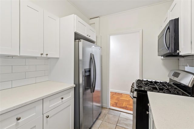 kitchen featuring tasteful backsplash, white cabinets, light tile patterned flooring, and stainless steel appliances