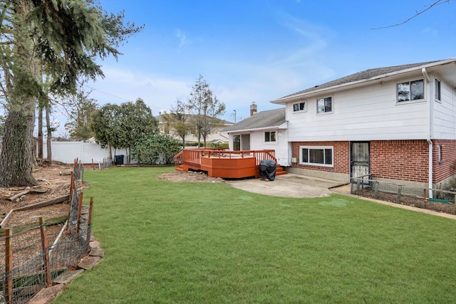 view of yard featuring a deck, a patio, and a fenced backyard