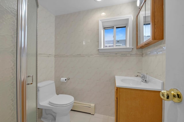 bathroom featuring toilet, vanity, tile walls, baseboard heating, and tile patterned floors