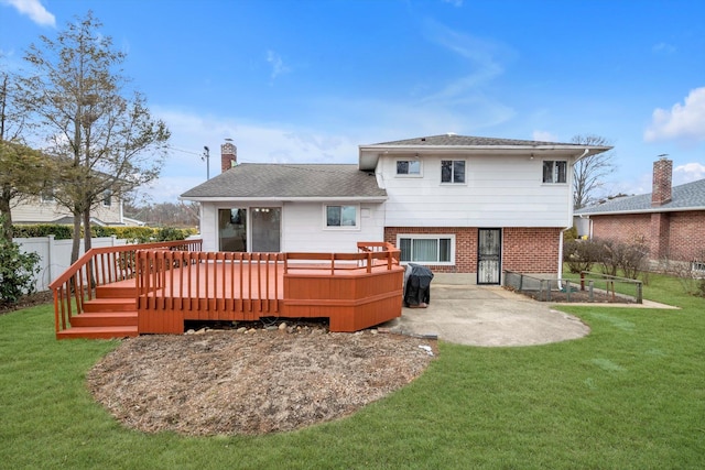 rear view of house featuring a patio, a lawn, a chimney, and a wooden deck