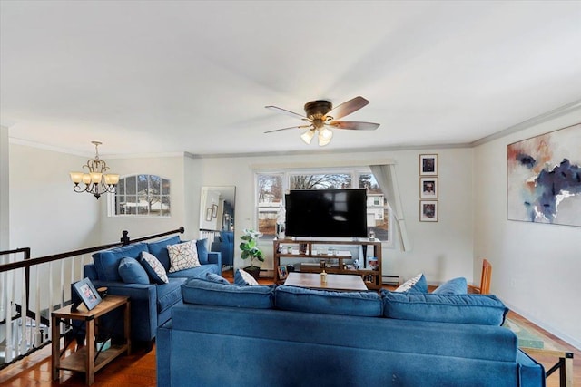 living room featuring baseboard heating, ceiling fan with notable chandelier, and crown molding