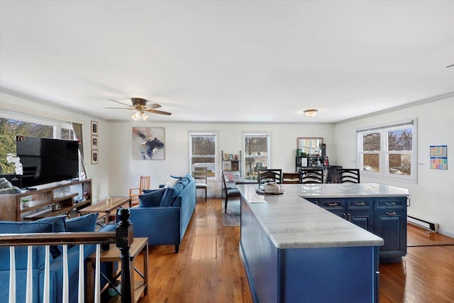 kitchen featuring hardwood / wood-style floors, crown molding, a kitchen island, and blue cabinets