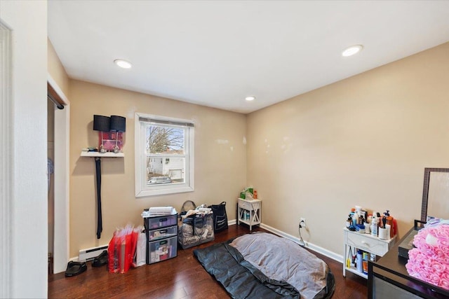 bedroom featuring a baseboard heating unit and dark hardwood / wood-style floors