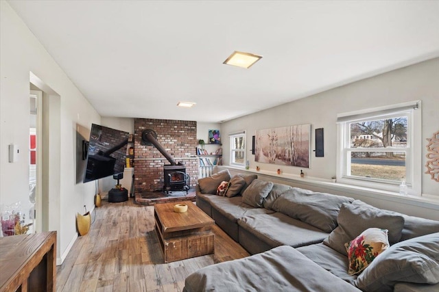 living room with a wood stove and wood-type flooring