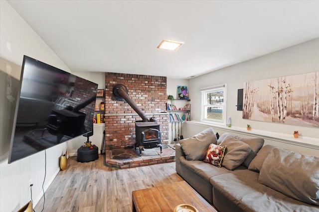 living room with a wood stove and light hardwood / wood-style flooring