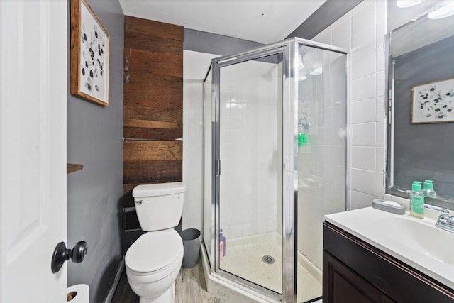 bathroom featuring toilet, vanity, and an enclosed shower