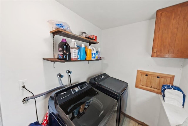 clothes washing area featuring cabinets and washing machine and clothes dryer