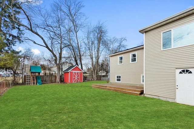 view of yard with a playground, a deck, and a storage unit