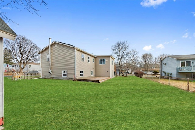 rear view of property with a lawn and a deck