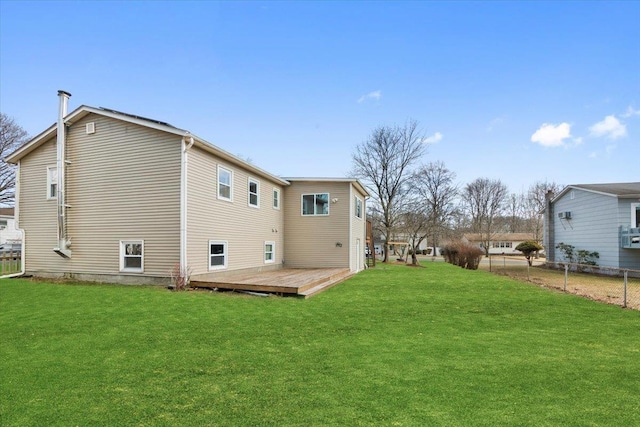 rear view of property with a wooden deck and a yard