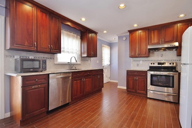 kitchen with sink, stainless steel appliances, ornamental molding, light stone countertops, and dark hardwood / wood-style flooring