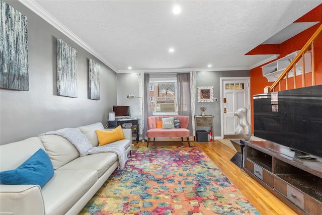 living room with cooling unit, crown molding, a textured ceiling, and light wood-type flooring