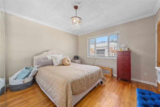 bedroom featuring an inviting chandelier, wood-type flooring, and ornamental molding