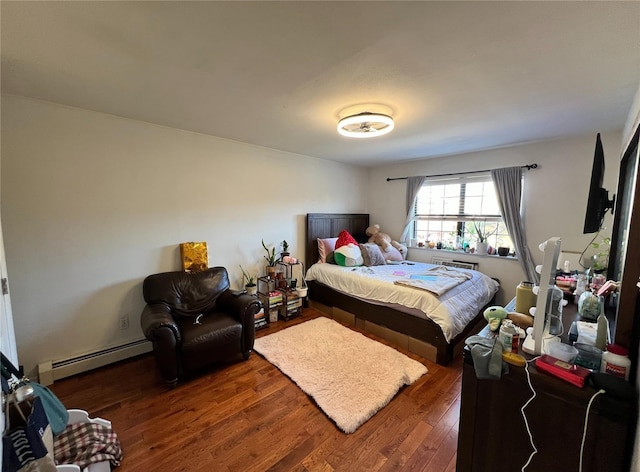 bedroom featuring dark hardwood / wood-style flooring and a baseboard heating unit