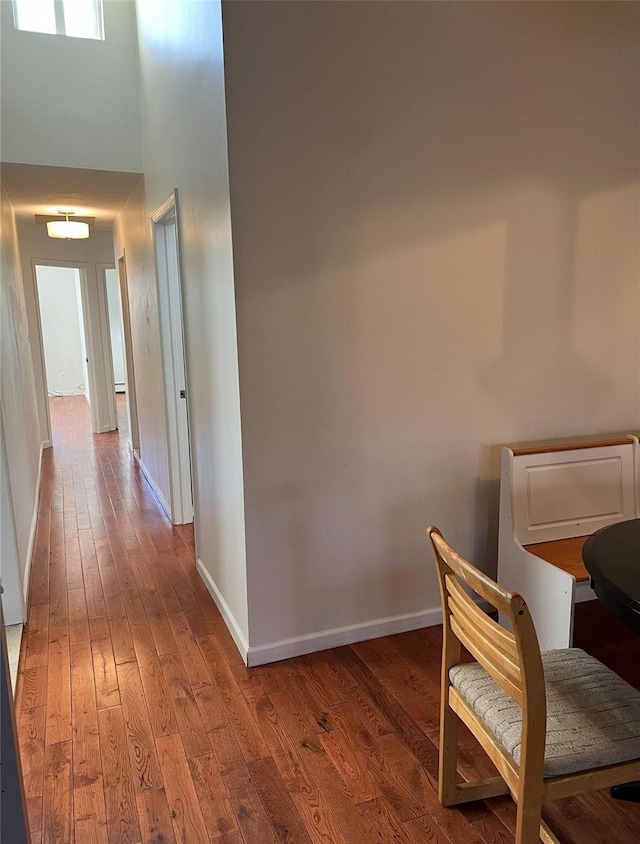 corridor featuring hardwood / wood-style floors and a towering ceiling