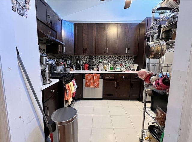 kitchen featuring dark brown cabinetry, lofted ceiling, stainless steel appliances, decorative backsplash, and light tile patterned floors