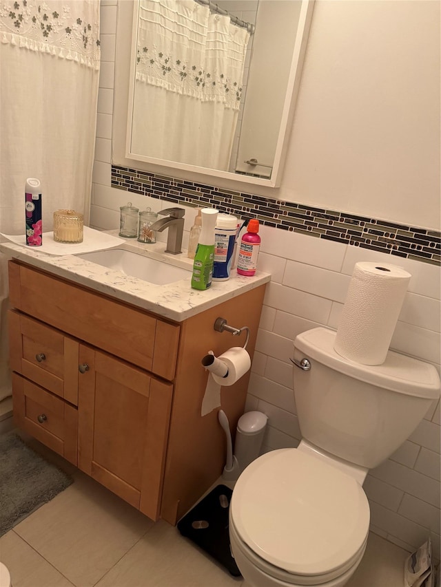 bathroom with vanity, tile patterned flooring, toilet, and tile walls