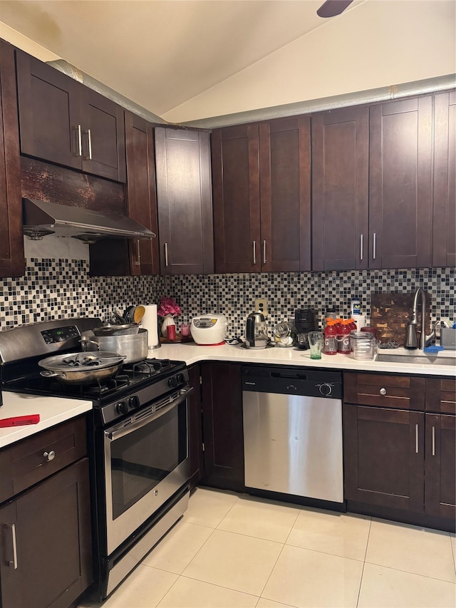 kitchen featuring lofted ceiling, sink, stainless steel appliances, dark brown cabinetry, and tasteful backsplash