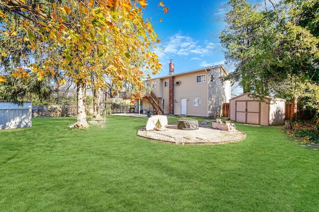 back of property with a patio area, an outdoor fire pit, a yard, and a storage unit