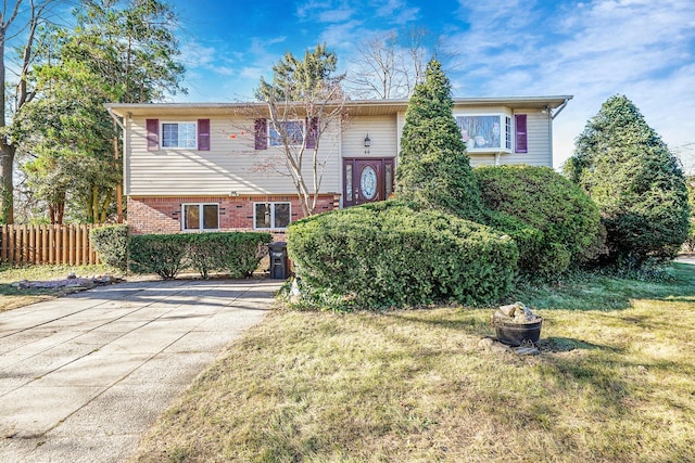 bi-level home with an outdoor fire pit and a front lawn