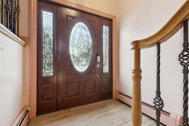 foyer with baseboard heating, plenty of natural light, and light wood-type flooring