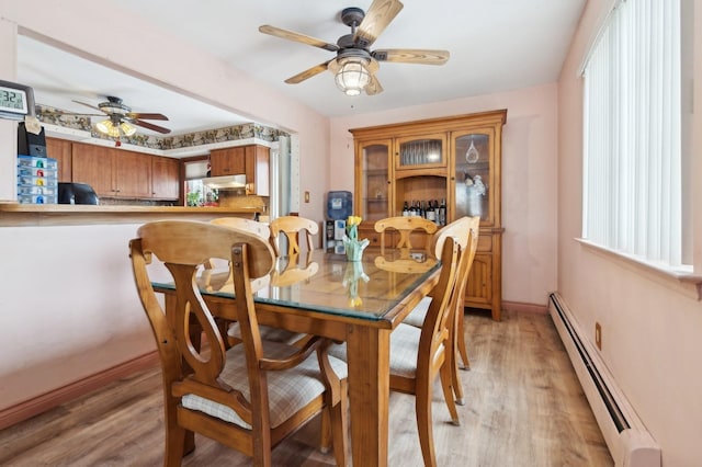 dining room featuring ceiling fan, light wood-type flooring, and a baseboard radiator