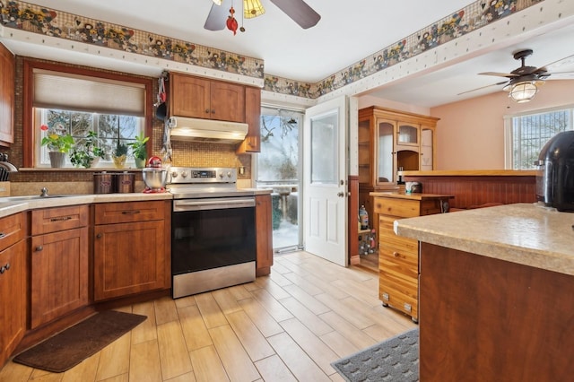 kitchen with ceiling fan, electric stove, light hardwood / wood-style flooring, and sink