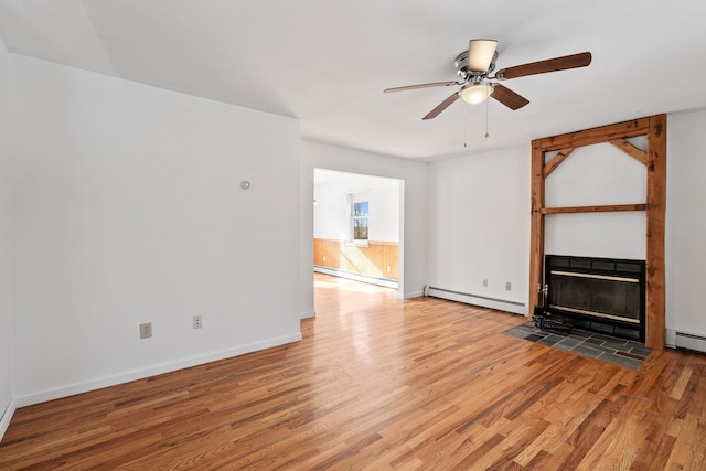 unfurnished living room featuring wood-type flooring, ceiling fan, and baseboard heating