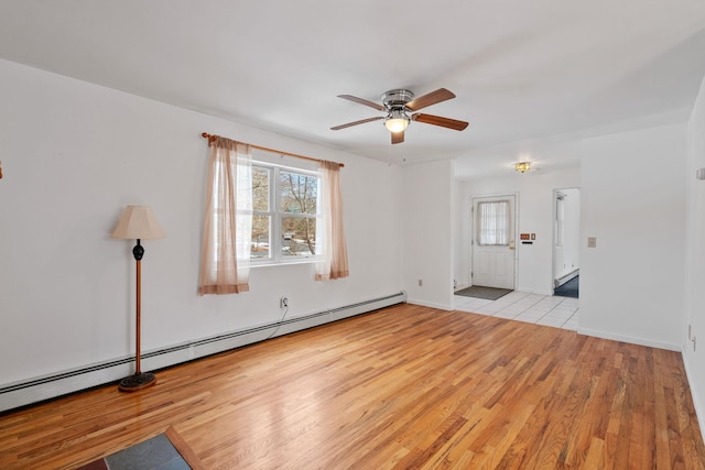 interior space featuring a baseboard heating unit, ceiling fan, and light wood-type flooring