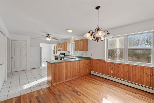 kitchen with sink, electric range, kitchen peninsula, white fridge, and a baseboard heating unit