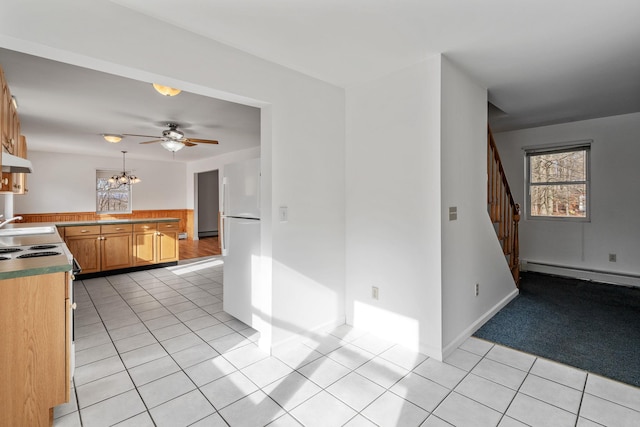 kitchen featuring light tile patterned flooring, a baseboard radiator, kitchen peninsula, and white fridge