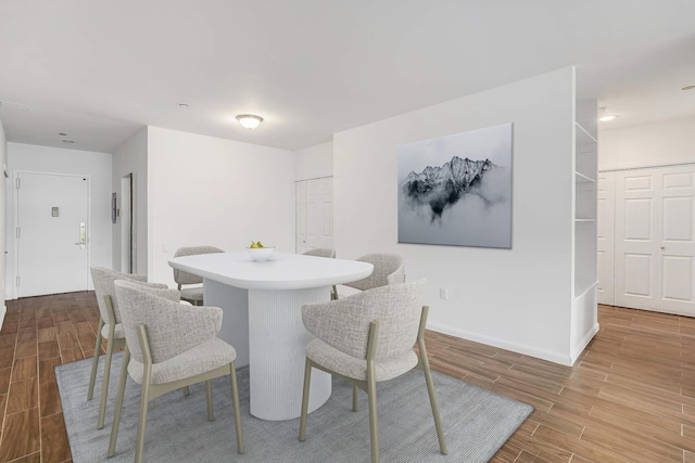 dining space with baseboards and wood finish floors