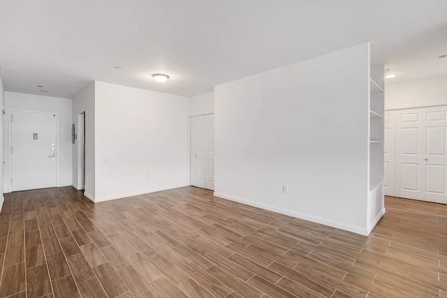 empty room featuring wood finish floors and baseboards