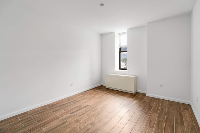 spare room featuring wood finished floors and baseboards