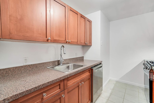 kitchen with light tile patterned floors, a sink, baseboards, appliances with stainless steel finishes, and dark countertops