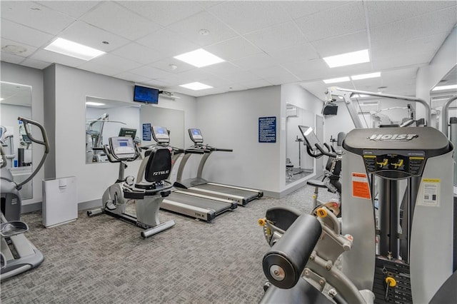 workout area with carpet, a paneled ceiling, and baseboards