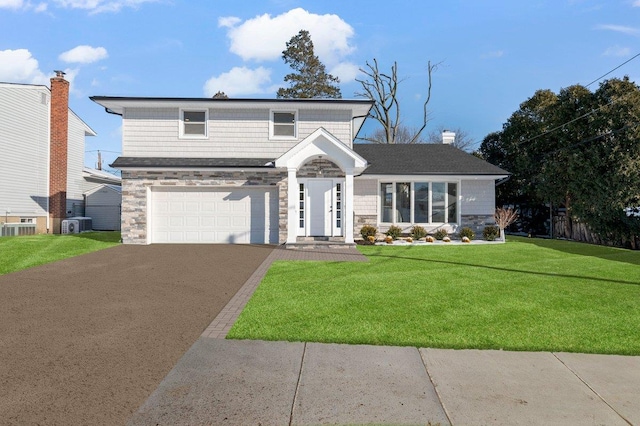 view of property with a garage, cooling unit, and a front lawn