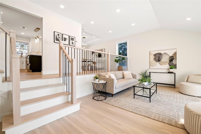 living room with wood-type flooring and vaulted ceiling