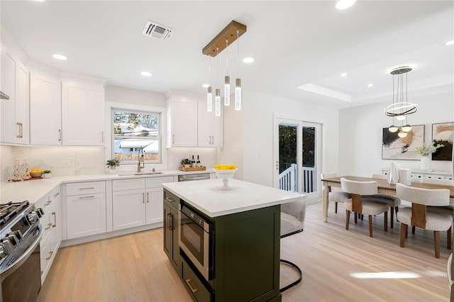 kitchen with a kitchen island, pendant lighting, and white cabinetry