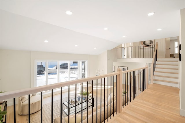 corridor featuring light hardwood / wood-style flooring and vaulted ceiling