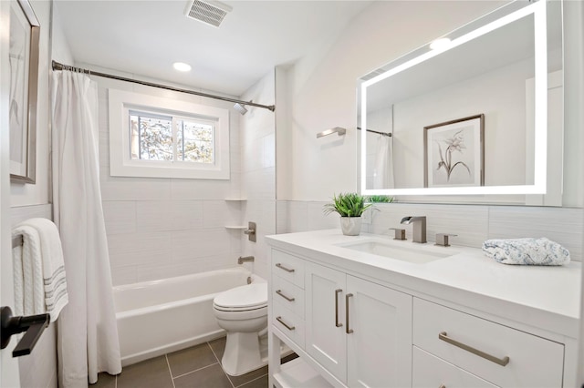 full bathroom featuring tile patterned floors, vanity, tasteful backsplash, toilet, and shower / bath combo with shower curtain